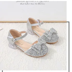 Close-up of girls' silver sequined princess shoes with bow detail and crystal heel