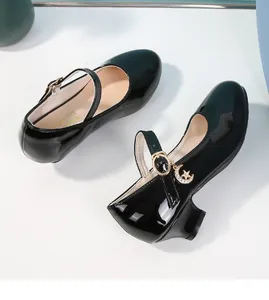 Dettaglio scarpe Mary Jane da bambina in vernice nera con ciondoli a stella e luna