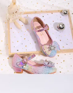 Detailed macro view of sparkly gradient princess shoes with sequin bow and pearl charm