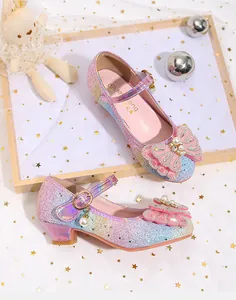 Vista macro de tela brillante arcoíris y lazo rosa con perlas en zapatos de princesa para niña