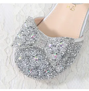 Close-up of sparkling silver princess shoes with rhinestone bow and star sequins