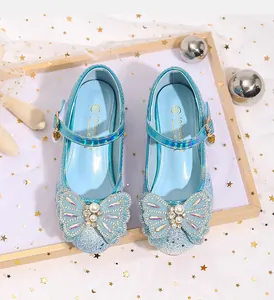 Detalle de zapatos de princesa azul claro para niña con purpurina y un lazo de pedrería