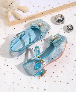 Detalle de zapatos de princesa con purpurina azul con pedrería y lazo de perlas