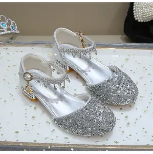 Detalle de zapatos de princesa plateados con lentejuelas brillantes y borlas de strass