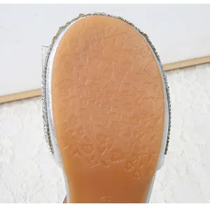 Detailed view of non-slip rubber sole with floral patterns and bead trim on silver shoes