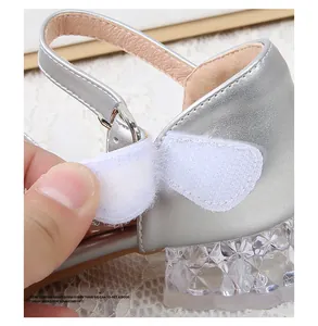 Detailed macro of the velcro strap and faceted crystal heel on silver princess shoes