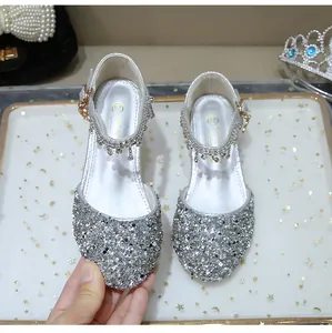 Detalle de zapatos Mary Jane de lentejuelas plateadas con borlas de pedrería y hebilla