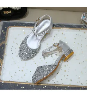 Detalle de zapatos de princesa plateados brillantes con pedrería y colgantes de luna