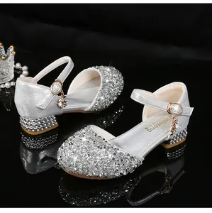 Detalle de zapatos Mary Jane plateados con purpurina y pedrería con hebilla al tobillo