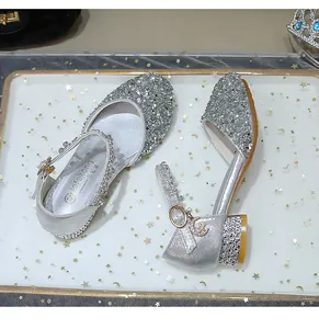 Detalle de zapatos Mary Jane plateados brillantes con pedrería y colgantes de luna
