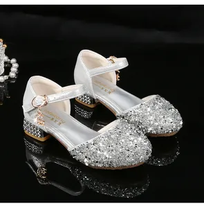 Detalle de zapatos Mary Jane plateados con lentejuelas y colgante de estrella