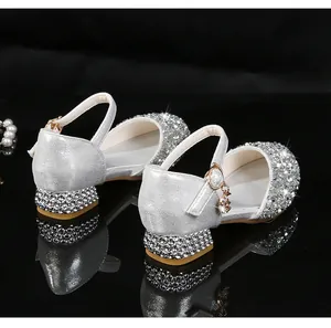 Detalle de zapatos de princesa plateados con pedrería brillante y colgante de estrella