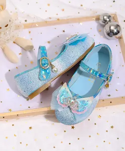 Detail of light blue girls mary jane shoes featuring sequins and a small crown charm