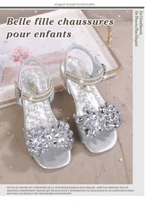 Détail de la fleur en strass scintillants et perles sur les sandales argentées de princesse