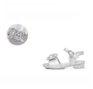 Détails des sandales argentées avec fleurs en strass et pendentif en forme de cœur
