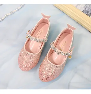 Détail de chaussures de princesse à paillettes roses et dorées avec strass et perle