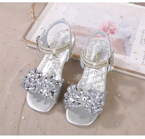 Détail de sandales argentées pour filles avec strass brillants et perles élégantes