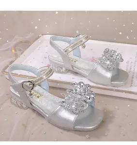 Détail de sandales princesse argentées avec fleurs en cristal et brides de perles