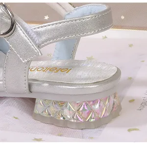Détail de sandales argentées pour filles avec talon en cristal et finition strass