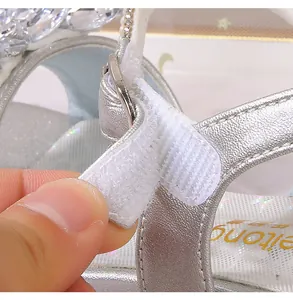 Détail de la sandale argentée pour enfant montrant la fermeture velcro et les strass