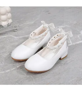 Close-up of white Mary Jane shoes for girls with pearl ankle strap and bow detail