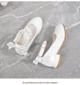 Detailed side view of white Mary Jane shoes with pearls, bow detail, and low block heels