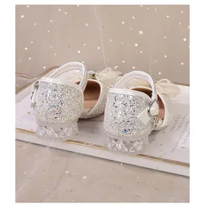 Detail von glitzernden Prinzessinnenschuhen für Mädchen mit Kristallabsatz und Schleife