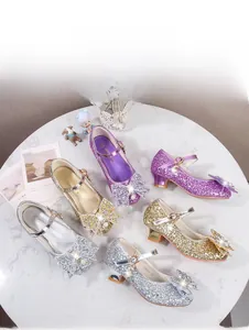 Détail de chaussures de princesse à paillettes avec nœuds en perles en or, argent et violet