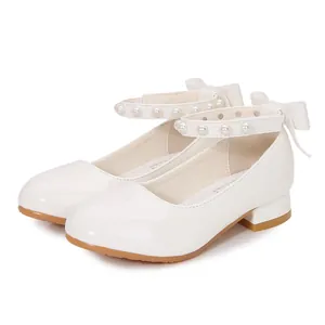 White patent leather Mary Jane girls' shoes with pearl strap and bow detail on the heel