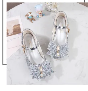 Détail de chaussures Mary Jane argentées pour filles avec pendentif perle et nœud à paillettes