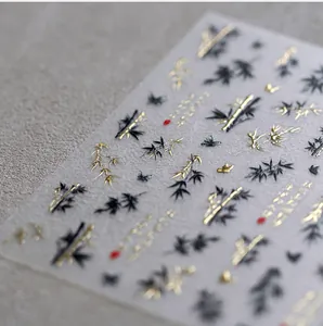 Macro shot of 3D embossed nail stickers featuring ink bamboo and butterfly patterns