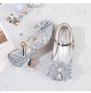 Détail de chaussures de princesse argentées pour filles avec nœud en perles et paillettes