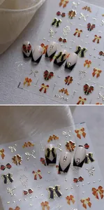 Close-up of 3D embossed golden bow nail stickers on French manicure with rhinestones