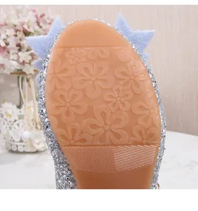 Détail de chaussure pailletée pour fille avec semelle antidérapante à motif floral