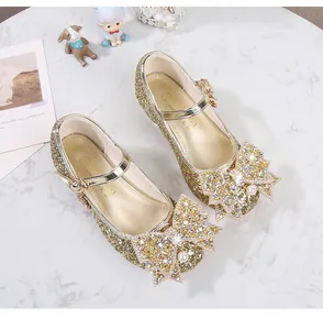Vue détaillée de chaussures Mary Jane dorées à paillettes avec nœud strass et perle
