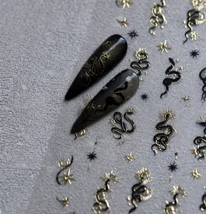 Detail von metallischen Schlangen- und Sternen-Nagelstickern auf dunklen Kunstnägeln