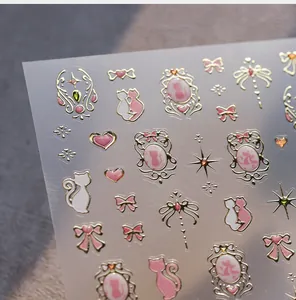 Detailed view of pink nail art stickers with gold foil cats and heart motifs