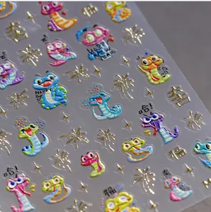 Detalle macro de pegatinas 3D para uñas con motivos de serpientes para el año nuevo 2025