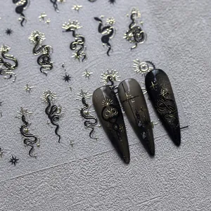 Gotische Nagelaufkleber mit Goldfolie, Schlangen und Sonnenmotiven auf dunklen Nägeln