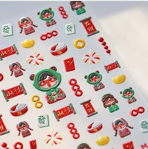 Macro shot of 3D embossed Chinese New Year nail stickers with gold ingots and scrolls