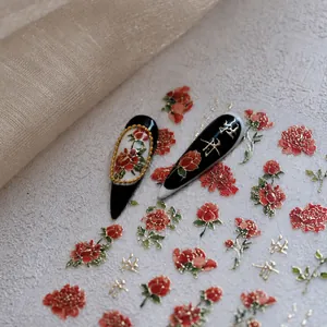 Detailed macro view of 3D embossed peony nail stickers with gold leaf calligraphy