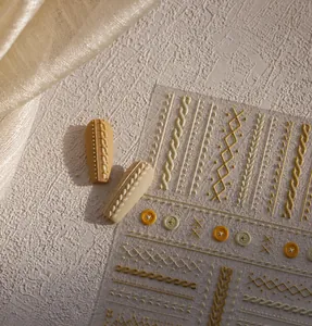 Detail of 3D embossed nail stickers featuring autumn sweater textures and cable patterns