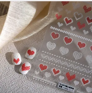 Vue macro détaillée des stickers nail art 3D gaufrés avec motif coeur et tricot rose