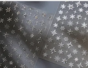 Macro view of 3D metallic snowflake nail art stickers with sparkling rhinestones