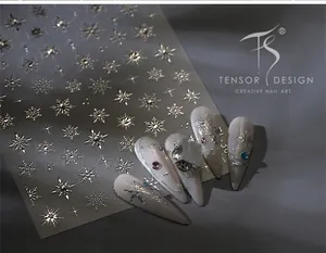 Close-up of silver snowflake nail stickers with rhinestones on light-colored nails
