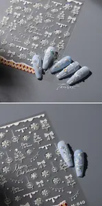 Dettaglio macro degli adesivi per unghie 3D con fiocchi di neve e alberi di Natale M-840