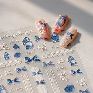 3D embossed nail art stickers with blue bows and white floral patterns for manicure