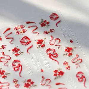 Detail of embossed snake and plum blossom nail stickers with golden shimmer for New Year