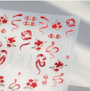 Macro detail of 3D embossed red snake and floral nail stickers in Chinese style