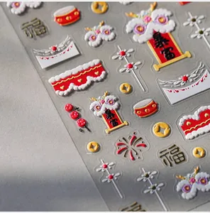 Macro shot of 3D embossed New Year nail stickers featuring lion dance and lucky motifs